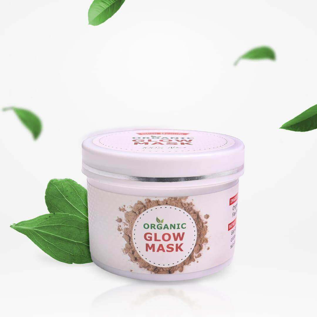 Organic Glow Mask container with fresh green leaves for radiant skin and natural skincare.